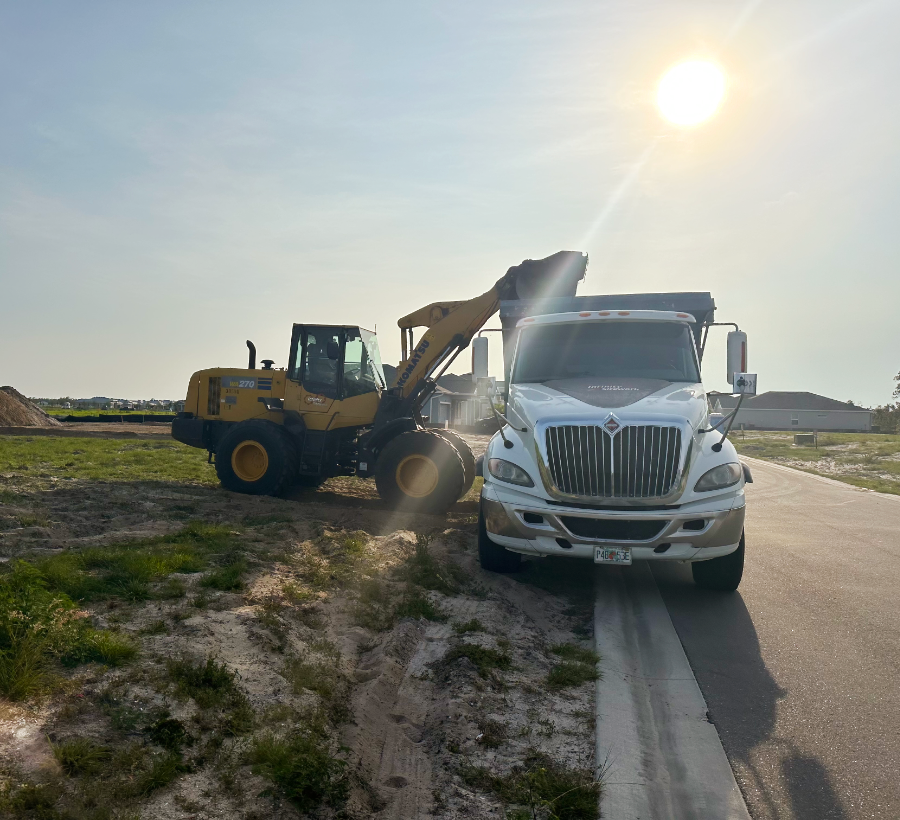 Escavator loading dirt into a dump truck