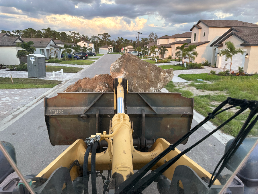 Escavator moving a large rock